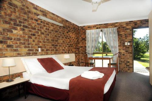a hotel room with a bed and a window at Annalee Motel Beaudesert in Beaudesert