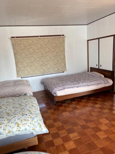 a bedroom with two beds and a window at 多賀三宿 in Taga