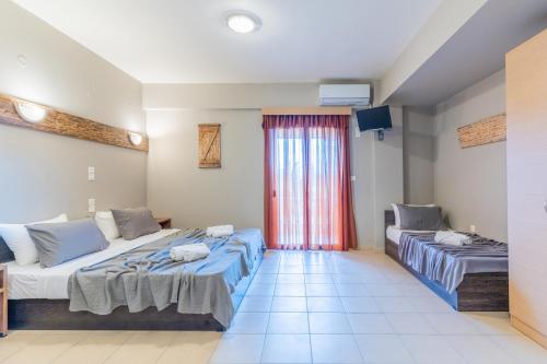 a hotel room with two beds and a window at Iliovasilema Hotel in Mytikas