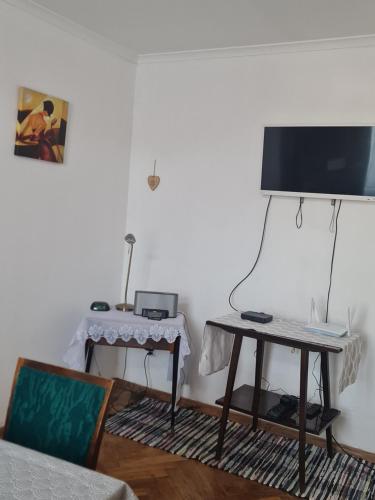a living room with a table and a television at Noclegi w Sercu Miasta in Sanok