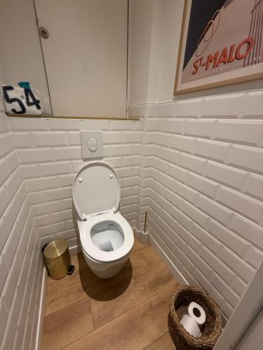 a bathroom with a toilet and a basket of toilet paper at Le Plongeoir, intra-muros in Saint Malo