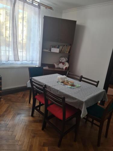 a dining room with a table with chairs and a teddy bear at Noclegi w Sercu Miasta in Sanok