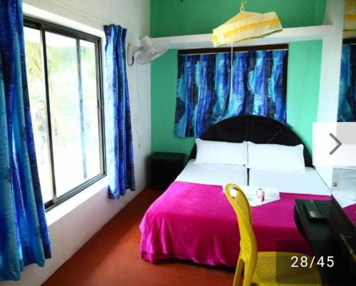 a bedroom with a bed and a desk and a window at Funky Art Beach House in Alleppey