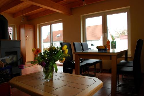 eine Vase mit Blumen auf einem Tisch im Wohnzimmer in der Unterkunft Ferienhaus Klaus und Walter in Mechelsdorf