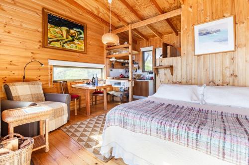 a bedroom with a bed and a dining room at Horizonte Infinito in Tunquén