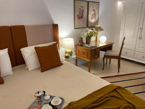 a bedroom with a bed and a desk and a table with cups and plates at Dimora Lùmina in Gallipoli
