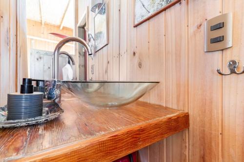 a bathroom sink with a glass bowl on a wooden counter at Horizonte Infinito in Tunquén