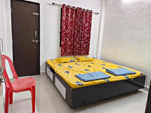 a bedroom with a bed and a red curtain at Durga Bhakt Niwas in Tuljapur
