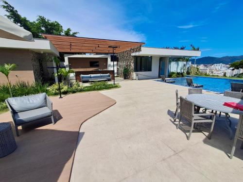 a patio with a table and chairs and a pool at Loft Próximo à Praia de Icaraí in Niterói
