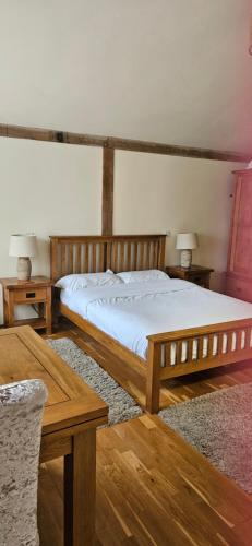 a bedroom with a wooden bed and two tables at The Chalet in Oxford