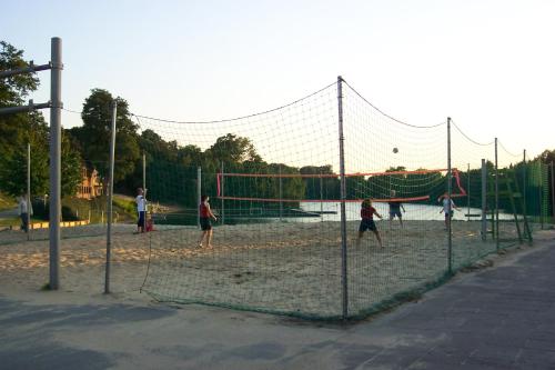 a group of people playing a game of volleyball at Gruppenunterkunft am Waldsee in Krefeld