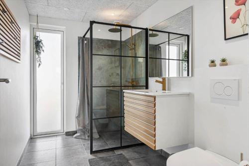a bathroom with a glass shower and a sink at SB128-Krusa-Hyldemose-23 in Skovbyballe
