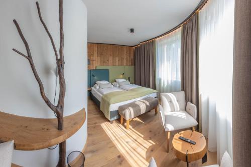 a bedroom with a bed and a tree in it at Hotel Sole Felsen Welt in Gmünd