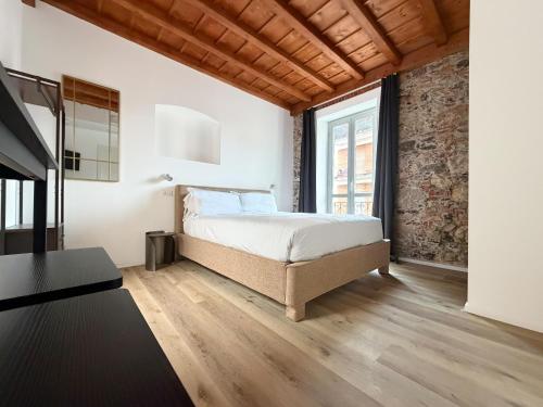 a bedroom with a bed and a brick wall at Palazzo Garbusi in Sarzana