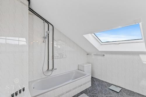 a bathroom with a bath tub and a window at Appartement à Schifflange in Schifflange