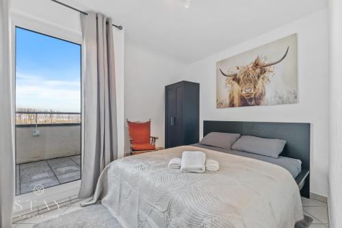a bedroom with a bed and a large window at Appartement à Schifflange in Schifflange