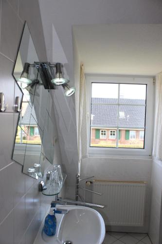 a bathroom with a sink and a mirror and a window at Landhaus Behrenwalde in Weitenhagen