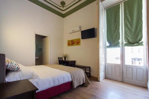 a bedroom with a bed and a large window at Cianciana in Catania