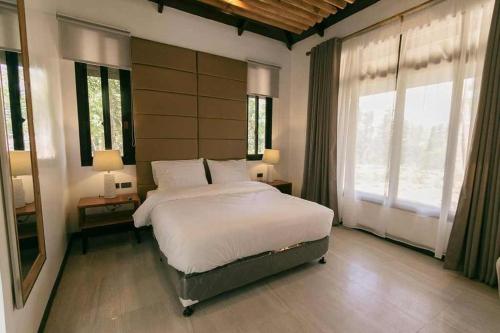 a bedroom with a large bed and a large window at Amaya View in Balulang
