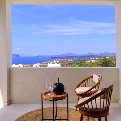 a room with a table and two chairs and a window at Potnia Theron Suites in Akrotiri