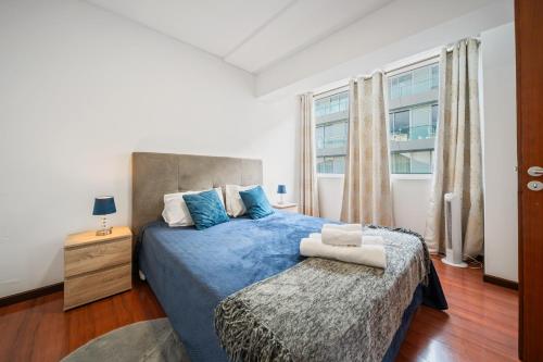 a bedroom with a blue bed and a window at Funchal Paradise in Funchal