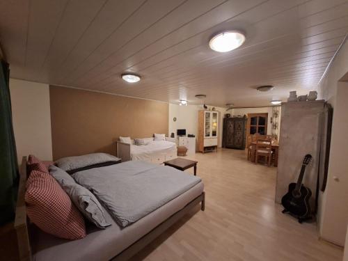 a bedroom with a bed and a room with a guitar at Bio-Bauernhof, Pferdehof Gräser in Viehberg