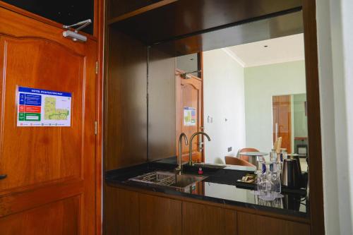a kitchen counter with a sink and a mirror at Best Western Dodoma City Hotel in Dodoma