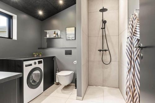 a bathroom with a washing machine and a shower at LK2209-Lokken-Soltoften-50 in Nørre Lyngby