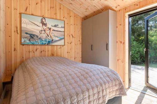 a bedroom with a bed and a picture of a woman on a bike at LK2209-Lokken-Soltoften-50 in Nørre Lyngby