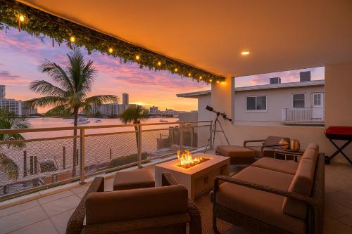 a living room with a balcony with a sunset at Waterfront 3bed | Pool | 10min walk to Beach in Hallandale Beach