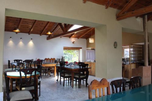 a dining room with wooden tables and chairs at Khali Estate in Binsar