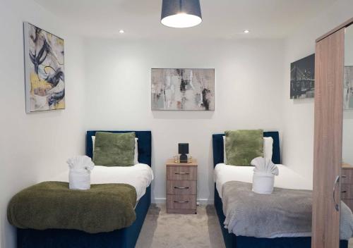 a bedroom with two twin beds with green cushions at Fort House Large 6BR Home Sleeps 12 3 Bathrooms NEC, JLR, BHX Nearby in Birmingham