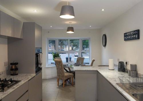 a kitchen with a counter and a table and chairs at Fort House Large 6BR Home Sleeps 12 3 Bathrooms NEC, JLR, BHX Nearby in Birmingham