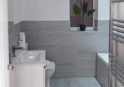 a bathroom with a white toilet and a sink at Fort House Large 6BR Home Sleeps 12 3 Bathrooms NEC, JLR, BHX Nearby in Birmingham