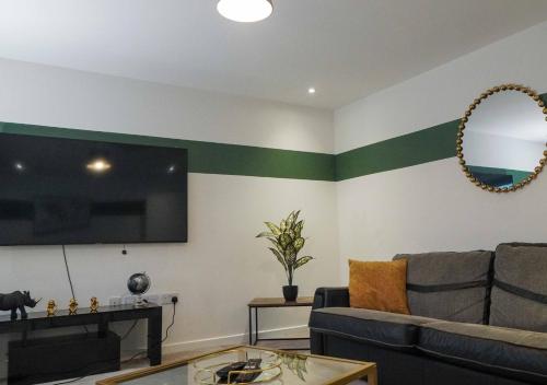 a living room with a couch and a flat screen tv at Fort House Large 6BR Home Sleeps 12 3 Bathrooms NEC, JLR, BHX Nearby in Birmingham