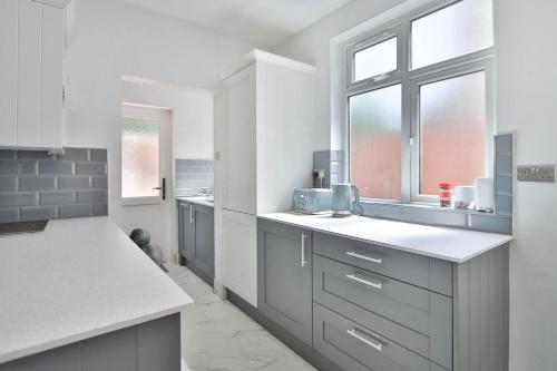 a kitchen with gray cabinets and a white counter top at Twin home with free parkings, Surbiton, Kingston upon Thames, Surrey, Greater London, UK! in Surbiton