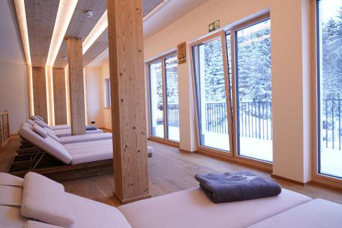 a living room with white furniture and large windows at Das Waldhotel - Genuss & Wellness am Notschreipass in Todtnau
