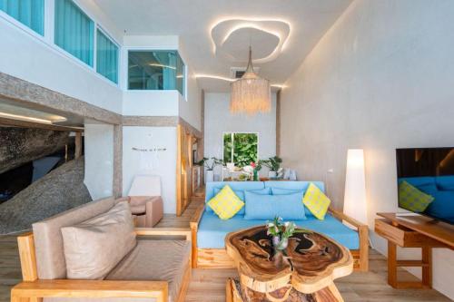 a living room with a couch and a table at The Rock Samui Beach Resort in Lamai