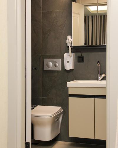 a bathroom with a toilet and a sink at Viva Nova Suit Hotel in Bakanlıklar