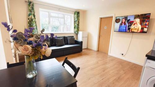 a living room with a vase of flowers on a table at Apple Garden B-4 in London