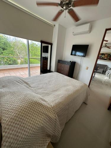 ein Schlafzimmer mit Bett und Deckenventilator in der Unterkunft CONDOMINIO LAGUNA CLUB "Amalfi" in Cartagena de Indias