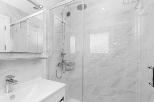 a white bathroom with a shower and a sink at Loch Earn in Inverness