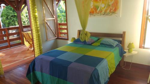 a bedroom with a colorful bed in a room at Gîte Les Palmistes in Vallée dʼOr