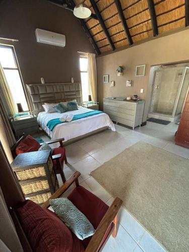 ein Schlafzimmer mit einem Bett und einer Couch in der Unterkunft Dorpsrus in Bela-Bela