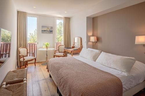 a hotel room with a bed and a balcony at Hôtel Briketenia in Guéthary