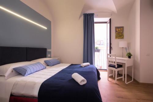 sypialnia z łóżkiem, biurkiem i oknem w obiekcie Cianciana w Katanii