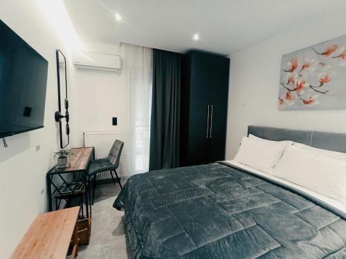 a bedroom with a bed and a table and a desk at Sodi Cozy apartment in Karditsa