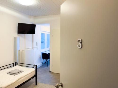 a room with a bed and a door with a table at CityStay Montabaur in Montabaur