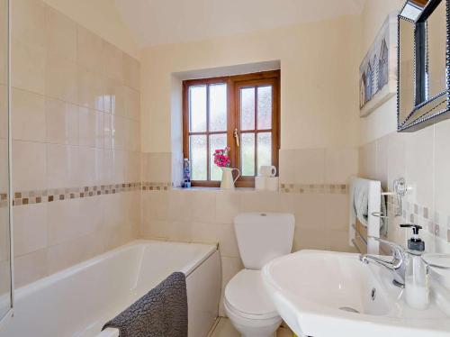 a bathroom with a tub and a toilet and a sink at 2 Bed in Norwich oc-64075 in East Harling