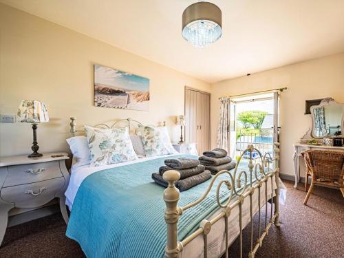 a bedroom with a bed with blue sheets and a window at 2 Bed in Camelford oc-81245 in Camelford